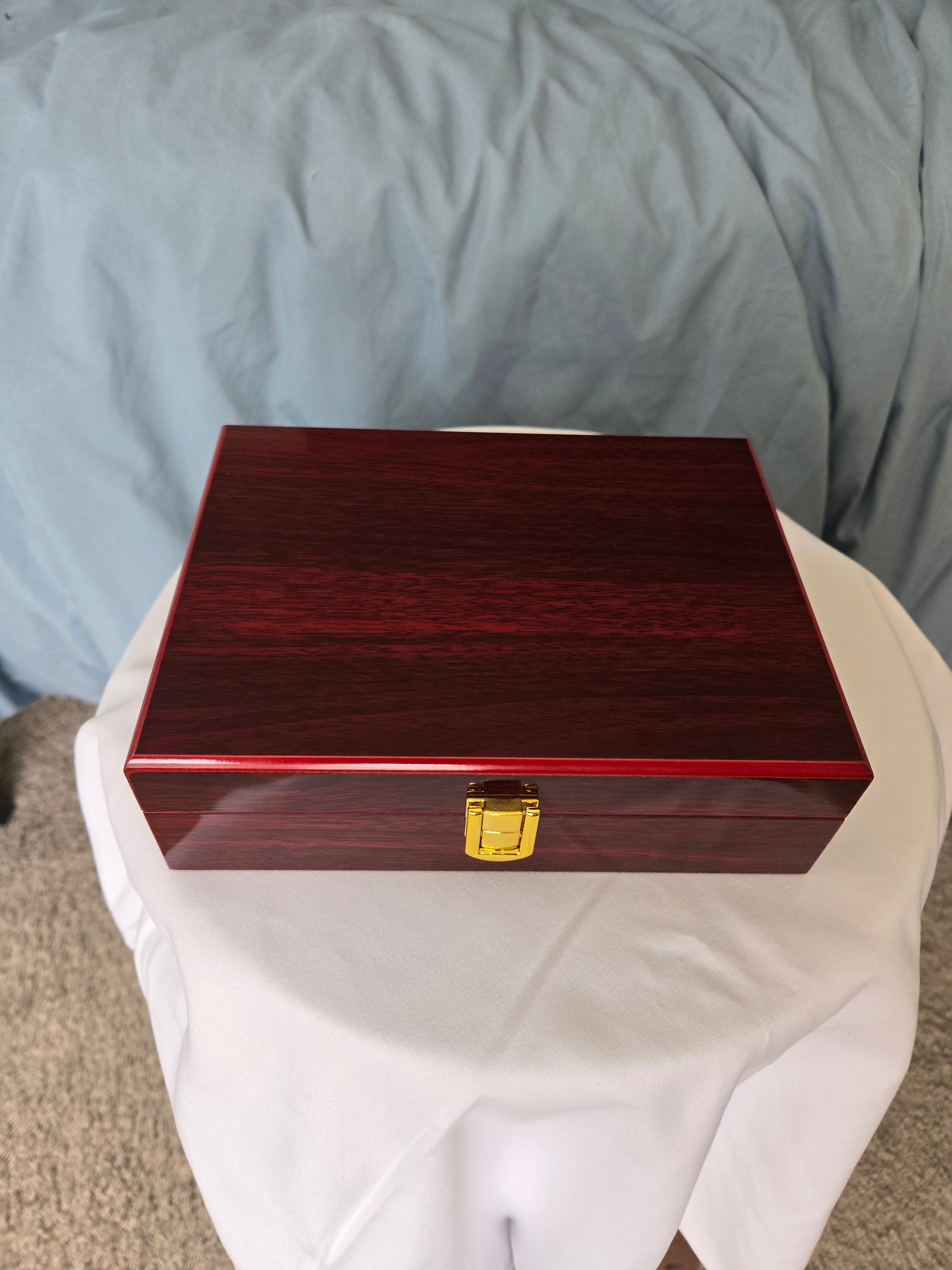 Red wooden jewelry box with a gold latch